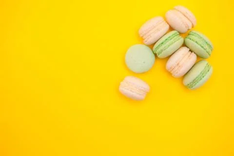 Assorted sweet fresh macaroons over yellow background Fotos Stock