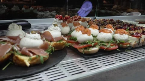 Assorted tapas with cheese cream salmon and toppings arranged on bread at Stock Footage 334969673