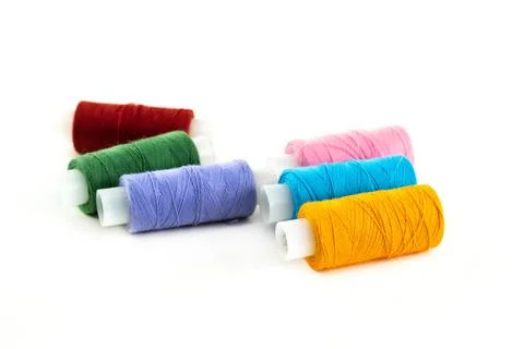 Assorted threads on a white bobbin multi-colored thread dark red Stock Photos