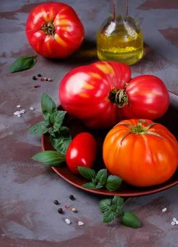 Assorted tomatoes, basil and olive oil Stock Photos
