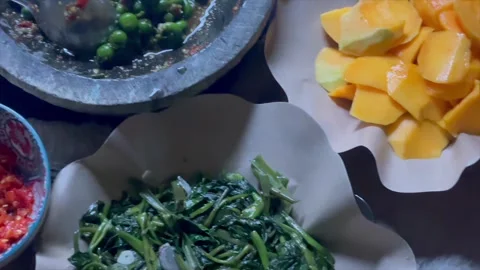 Assorted traditional Indonesian side dishes served on food wrapping paper 库存影片 340485741
