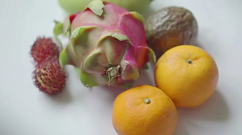 Assorted tropical fruit: rambutan, mango, dragon fruit, passionfruit, tangerine Stock Footage 67675347