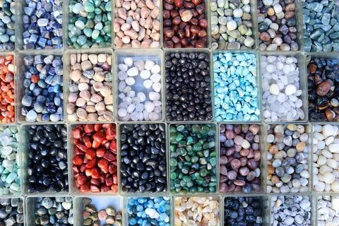 Assorted tumbled gemstones in boxes Stock Photos