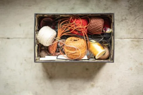 Assorted twines, string and thread rolls in an open container Stock Photos