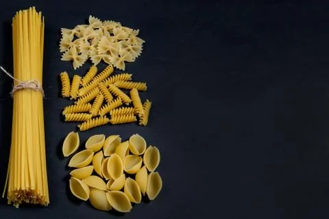 Assorted types of pasta on black background. Top view. Various forms of pasta Stock Photos