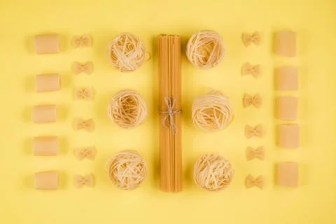 Assorted types of pasta on yellow background. Various forms of pasta. Stock Photos