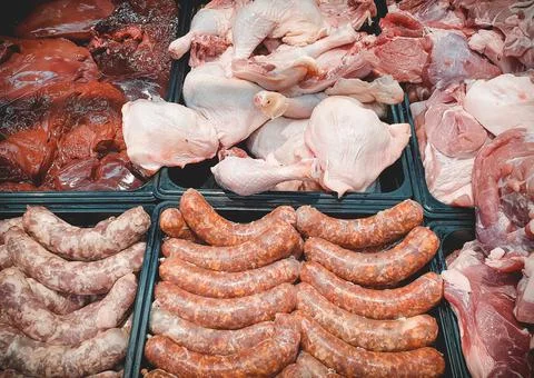 Assorted various fresh raw meat and meat products on market counter. Sausages Stock Photos