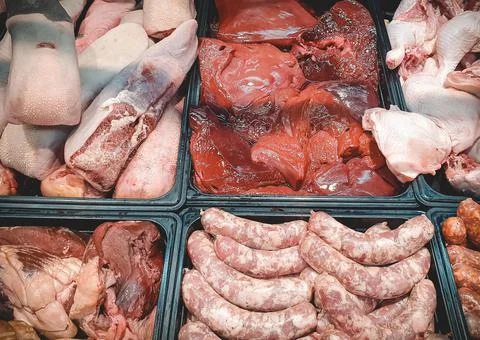 Assorted various fresh raw meat and meat products on market counter. Sausages Stock Photos