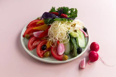 Assorted vegetables and various cheeses in a plate. Stock Photos