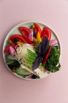 Assorted vegetables and various cheeses in a plate. Stock Photos