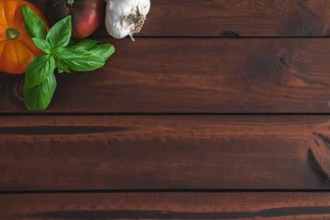 Assorted vegetables on a brown board for farm-to-table messaging. Stock Photos