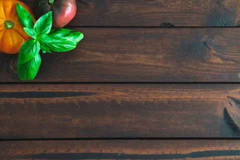 Assorted vegetables on a brown board for farm-to-table messaging. Stock Photos