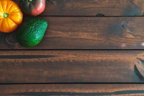 Assorted vegetables on a brown board for farm-to-table messaging. Stock Photos