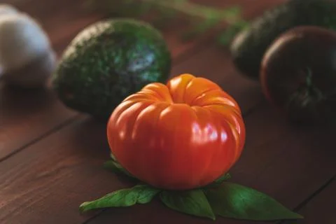 Assorted vegetables on a brown board for farm-to-table messaging. Stock Photos