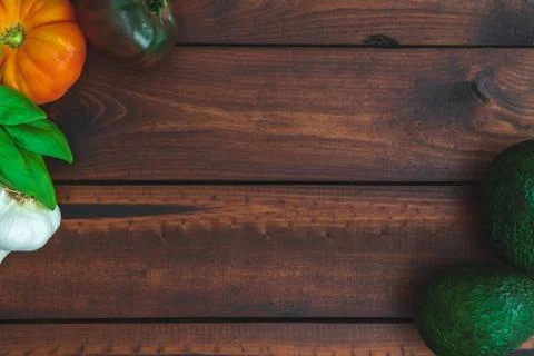 Assorted vegetables on brown table great for farm to table marketing. Stock Photos
