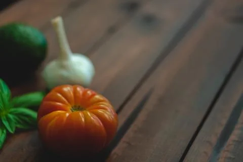 Assorted vegetables on brown table great for farm to table marketing. Stock Photos