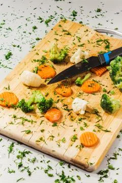 Assorted vegetables on a cutting board on a white table background, for a hea Stock Photos