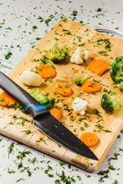 Assorted vegetables on a cutting board on a white table background, for a hea Stock Photos