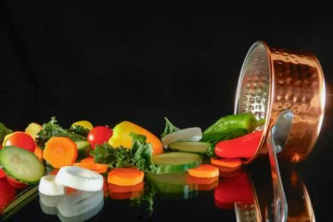 Assorted vegetables resting next to a saucepan Stock Photos