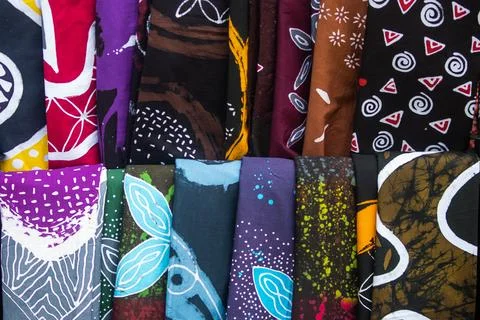 Assorted Vertical Batik Fabric Rolls in Souvenir Shop Background Stock Photos