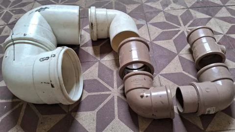 Assorted white and brown plastic plumbing pipe elbows and connectors Stock Photos