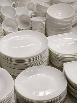 Assorted white ceramic dishes plates bowls cups and other items stacked on .. 스톡 사진