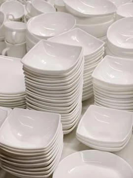 Assorted white ceramic tableware including stacked cups plates saucers and .. Stock Photos