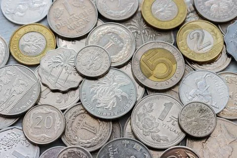 Assorted white coins from different countries on a white background, top view Stock Photos
