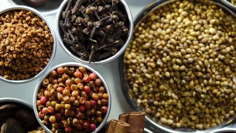 Assorted whole spices displayed in small silver metal bowls Video stock 333809887