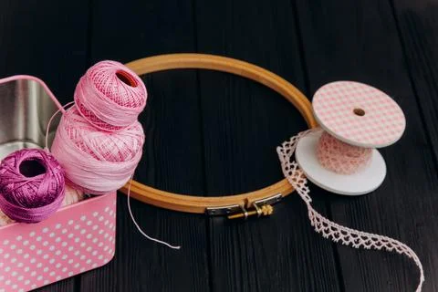 Assorted yarn and sewing tools in a pink tin box on a black wooden backgrou.. Stock Photos