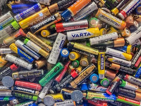 Assortment of assorted sized and colored batteries on light surface Kyiv, Ukr Stock Photos