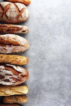 Assortment of baked bread and bread rolls on stone table background Stock Photos