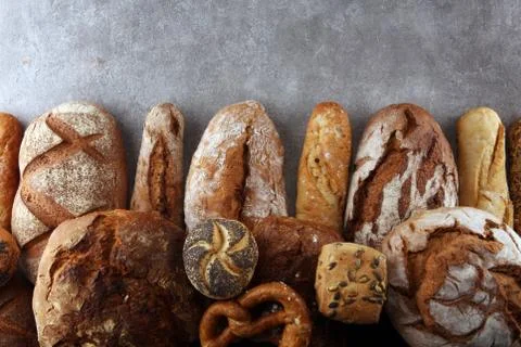 Assortment of baked bread and bread rolls on stone table background Stock Photos