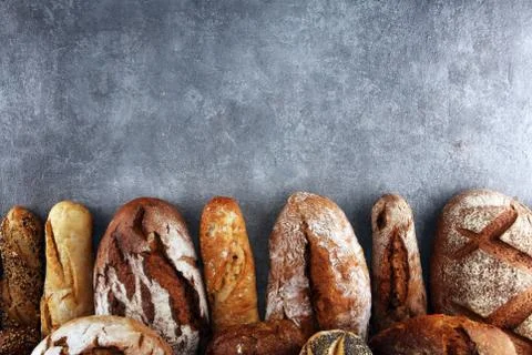 Assortment of baked bread and bread rolls on stone table background Stock Photos