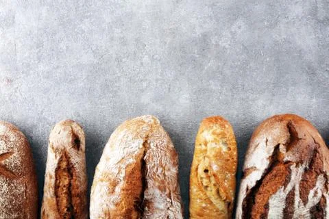 Assortment of baked bread and bread rolls on stone table background Stock Photos
