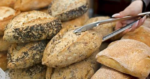 Assortment of baked bread in a bakery window display close-up Stock Photos