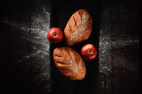Assortment of baked bread from rye and wheat flour on black background. Top view Stock Photos