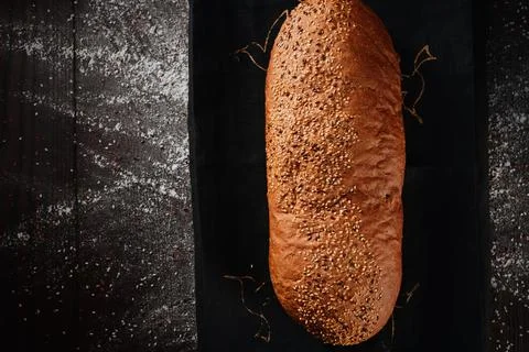 Assortment of baked bread from rye and wheat flour on black background. Top view Stock Photos