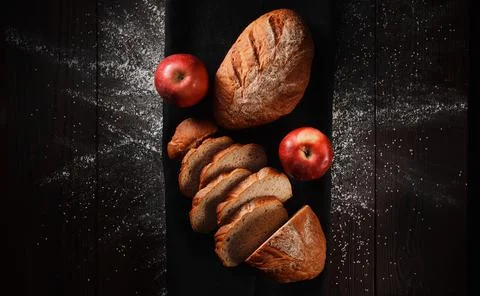Assortment of baked bread from rye and wheat flour on black background. Top view Stock Photos