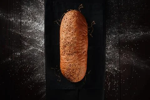 Assortment of baked bread from rye and wheat flour on black background. Top view Stock Photos