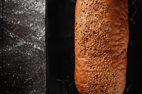 Assortment of baked bread from rye and wheat flour on black background. Top view Stock Photos