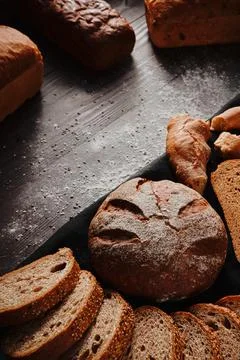 Assortment of baked bread from rye and wheat flour on black background. Top view Stock Photos