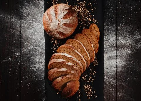 Assortment of baked bread from rye and wheat flour on black background. Top view Stock Photos