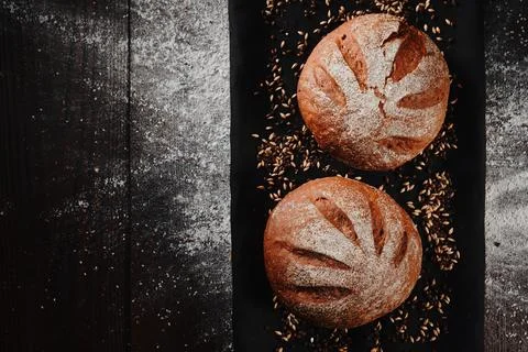 Assortment of baked bread from rye and wheat flour on black background. Top view Stock Photos