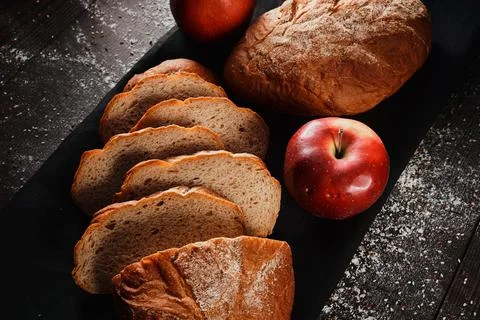 Assortment of baked bread from rye and wheat flour on black background. Top view Stock Photos
