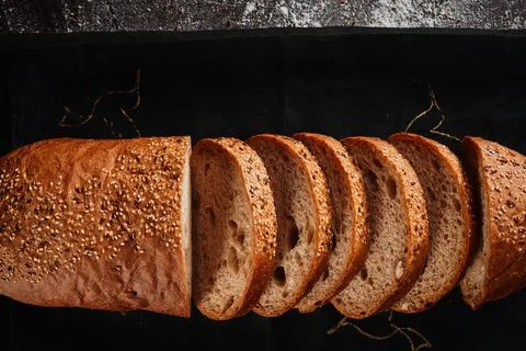 Assortment of baked bread from rye and wheat flour on black background. Top view Stock Photos