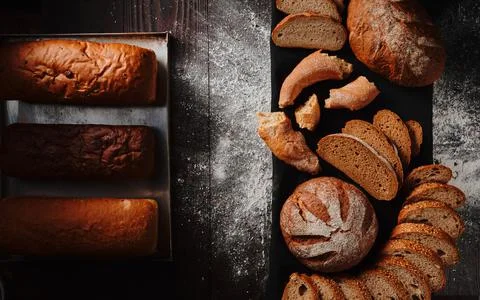 Assortment of baked bread from rye and wheat flour on black background. Top view Stock Photos