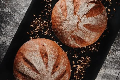 Assortment of baked bread from rye and wheat flour on black background. Top view Stock Photos