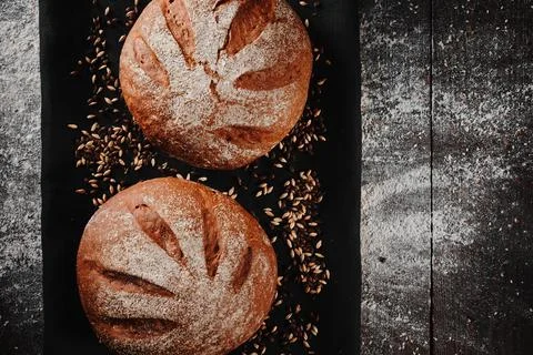 Assortment of baked bread from rye and wheat flour on black background. Top view Stock Photos