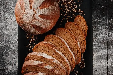 Assortment of baked bread from rye and wheat flour on black background. Top view Stock Photos